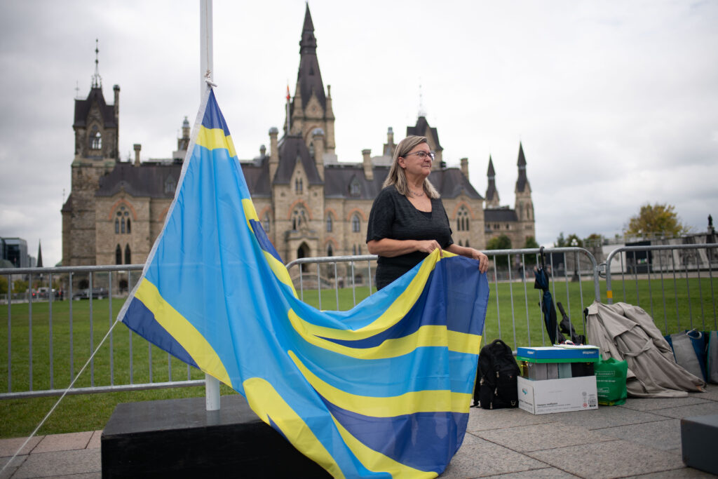 Hélène holding the Deaf Flag at Deaf Flag Raising event